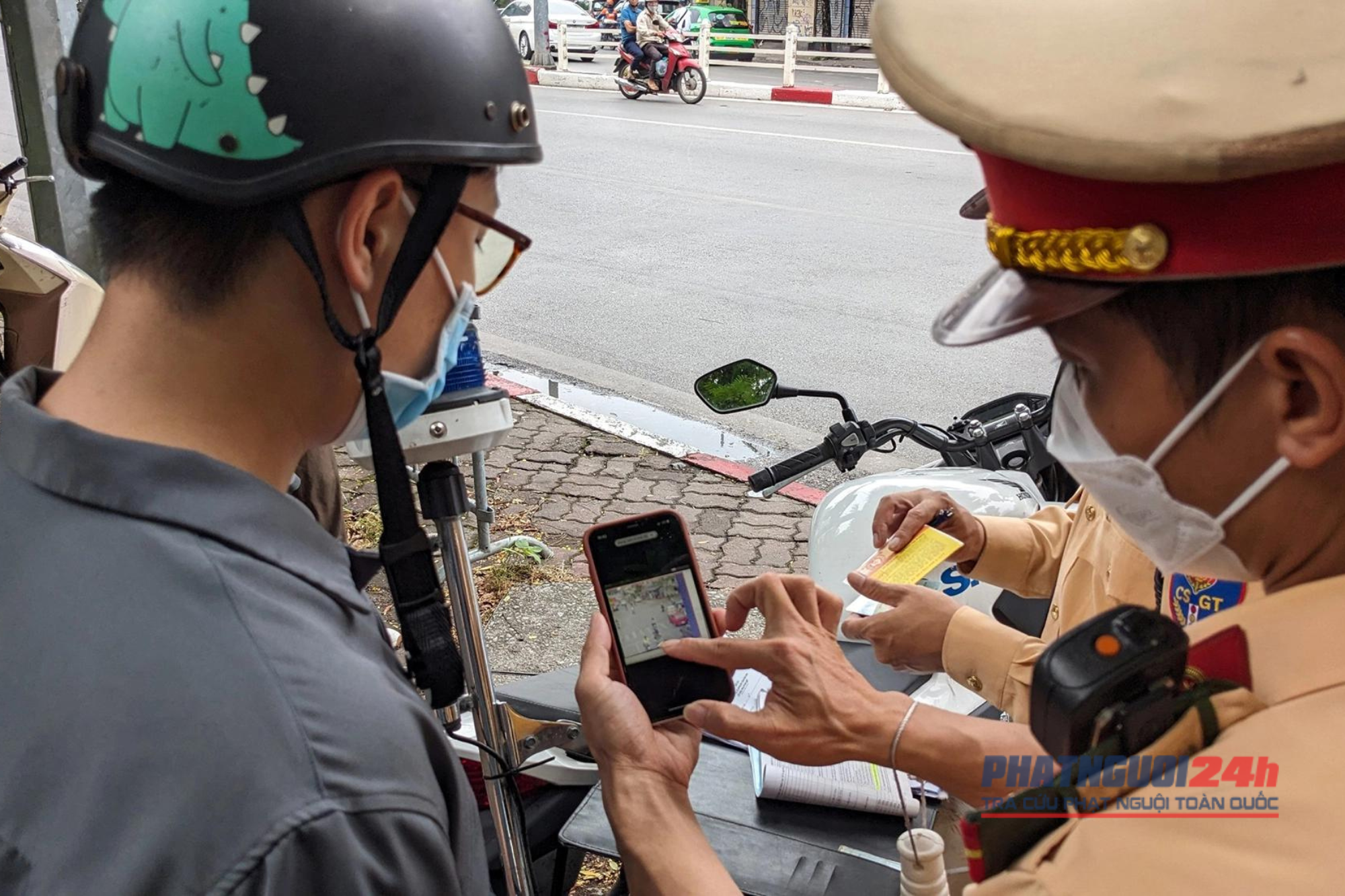 CSGT Đội 1, Phòng CSGT Công an Hà Nội cho một tài xế xe máy vi phạm giao thông xem lại hình ảnh hệ thống camera giám sát ghi lại.
