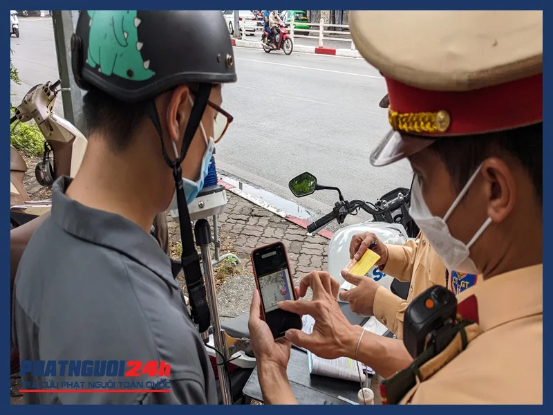  CSGT Công an Hà Nội cho một tài xế xe máy vi phạm giao thông xem lại hình ảnh hệ thống camera giám sát ghi lại.